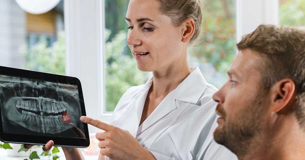 Il dentista visita il paziente per decidere come intervenire sui denti del giudizio problematici